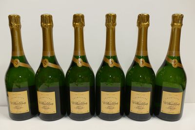six bottles of champagne lined up in a row on a white surface