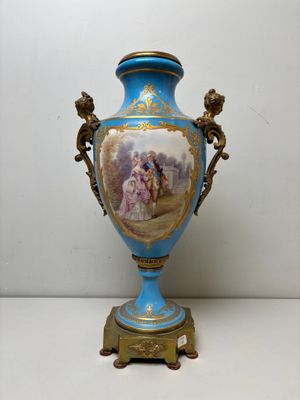 un vase bleu avec une peinture dessus, posé sur une table