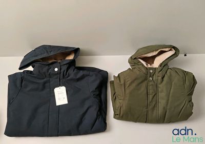 deux vestes à capuche sont posées l'une à côté de l'autre sur une table