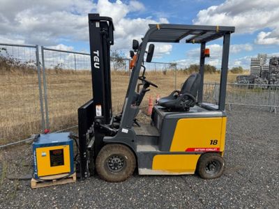a fork lift truck parked next to a fence