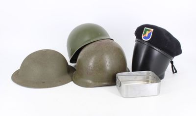 a helmet, a hat, and a tin on a white surface