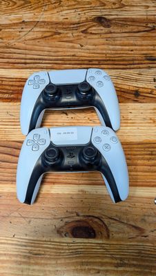 deux manettes de jeux vidéo posées sur une table en bois