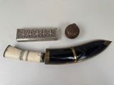 two pieces of silver and horn horn with a stamp on top of it