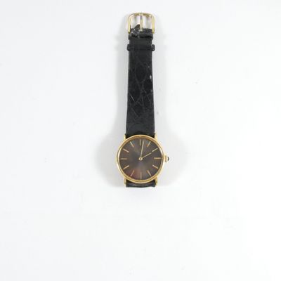 an image of a black and gold wrist watch on a white surface