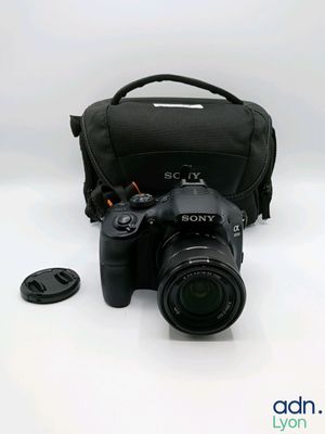 un appareil photo et un sac pour objectif posés sur la table