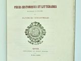 un livre ouvert sur lequel figure un blason