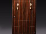 une armoire de style Art déco avec une porte en bois et des poignées en laiton