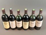 six bottles of wine are lined up in a row on a table