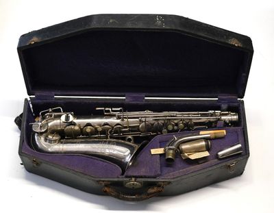 un saxophone dans son étui, posé sur une surface blanche