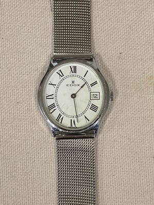 une image d'une montre en argent avec des chiffres romains sur le cadran