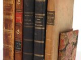 several old books are stacked on top of each other on a table