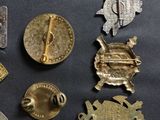 many different types of metal badges on a black surface