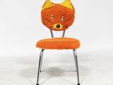 an orange chair with a cat head on top of it