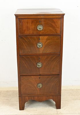 a small wooden chest of drawers on a tile floor