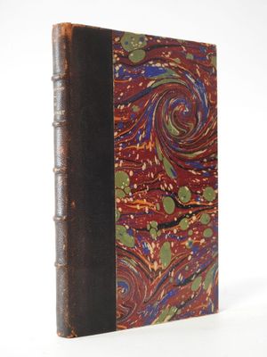 an old book sitting on top of a white surface with a spiral design