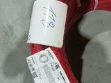a red hose that has been wrapped up and is sitting on the floor
