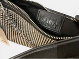 the zipper of a black purse with a chain hanging from it