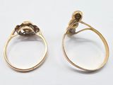 pair of gold rings with diamonds on them on a white surface