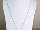 collier jaune et argenté avec un pendentif en forme de fleur sur un mannequin blanc