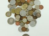 a pile of coins on a white surface next to a coin