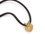 une photo d'un collier avec un cœur en or suspendu à un cordon noir