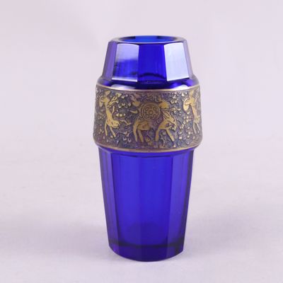 un verre bleu bordé d'or et un verre bleu bordé d'or posé dessus