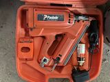 une boîte orange contenant une agrafeuse et une agrafeuse