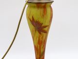 une lampe orange et jaune surmontée d'un oiseau