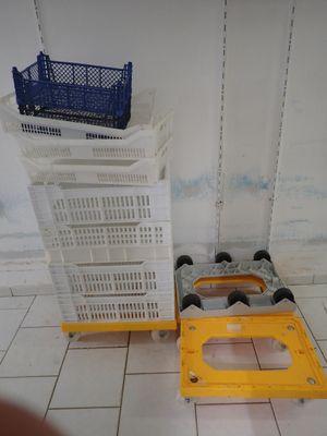 une pile de caisses et une caisse en plastique posée par terre