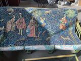 un banc recouvert d'une tapisserie dans une pièce