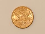 a close up of a gold coin on a white surface