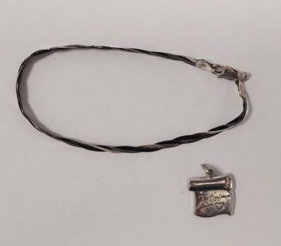 silver plated necklace with a small pendant on a black cord
