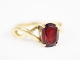 l'image d'une bague en or contenant une pierre rouge