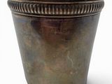 a metal pot that is sitting on a white surface