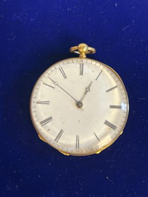 une horloge en or avec des chiffres romains sur le cadran