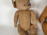 two teddy bears sitting next to each other on a white surface