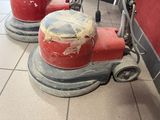 a red machine that is on the floor in a room