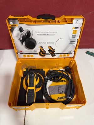 a yellow tool box with tools in it on a table