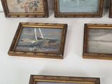 six framed paintings of boats on the water and a boat in the distance