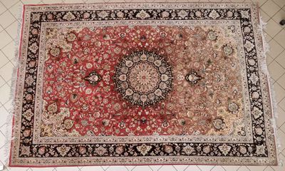 an image of a red and black rug on a white tiled floor