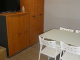 une table et des chaises blanches dans une pièce équipée d'une télévision