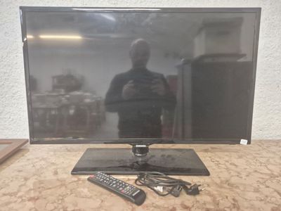 une télévision à écran plat posée sur une table, avec une télécommande