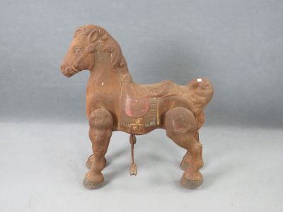 un petit cheval en bois avec une selle sur le dos