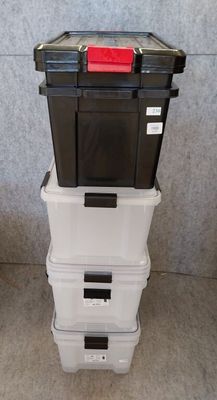 three plastic storage boxes stacked on top of each other in a room