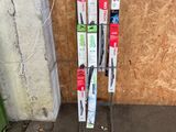 une photo montrant un râtelier de skis et de bâtons devant un immeuble