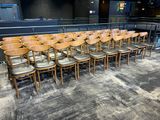 des rangées de chaises en bois dans un auditorium vide, avec une scène en arrière-plan