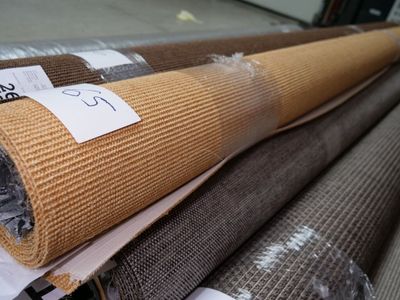 several rolls of carpet are stacked on top of each other in a warehouse