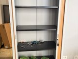 a cabinet with two shelves and two green boxes in it