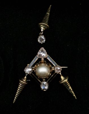 un gros plan sur un collier orné d'une perle et d'un diamant