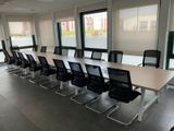 des tables et des chaises dans une grande salle de conférence dotée de grandes fenêtres